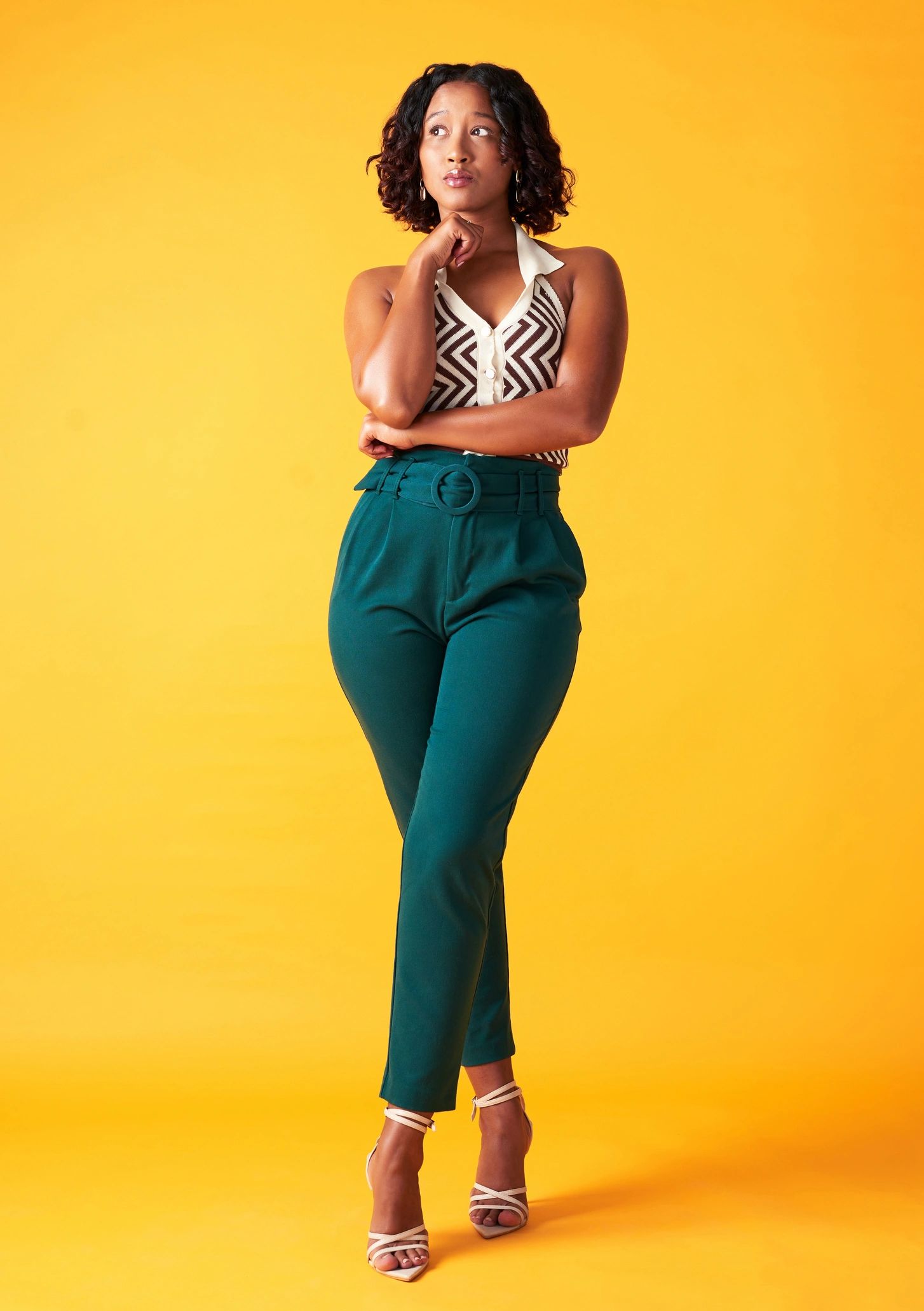 Fashion model in vintage-inspired clothing against a yellow backdrop